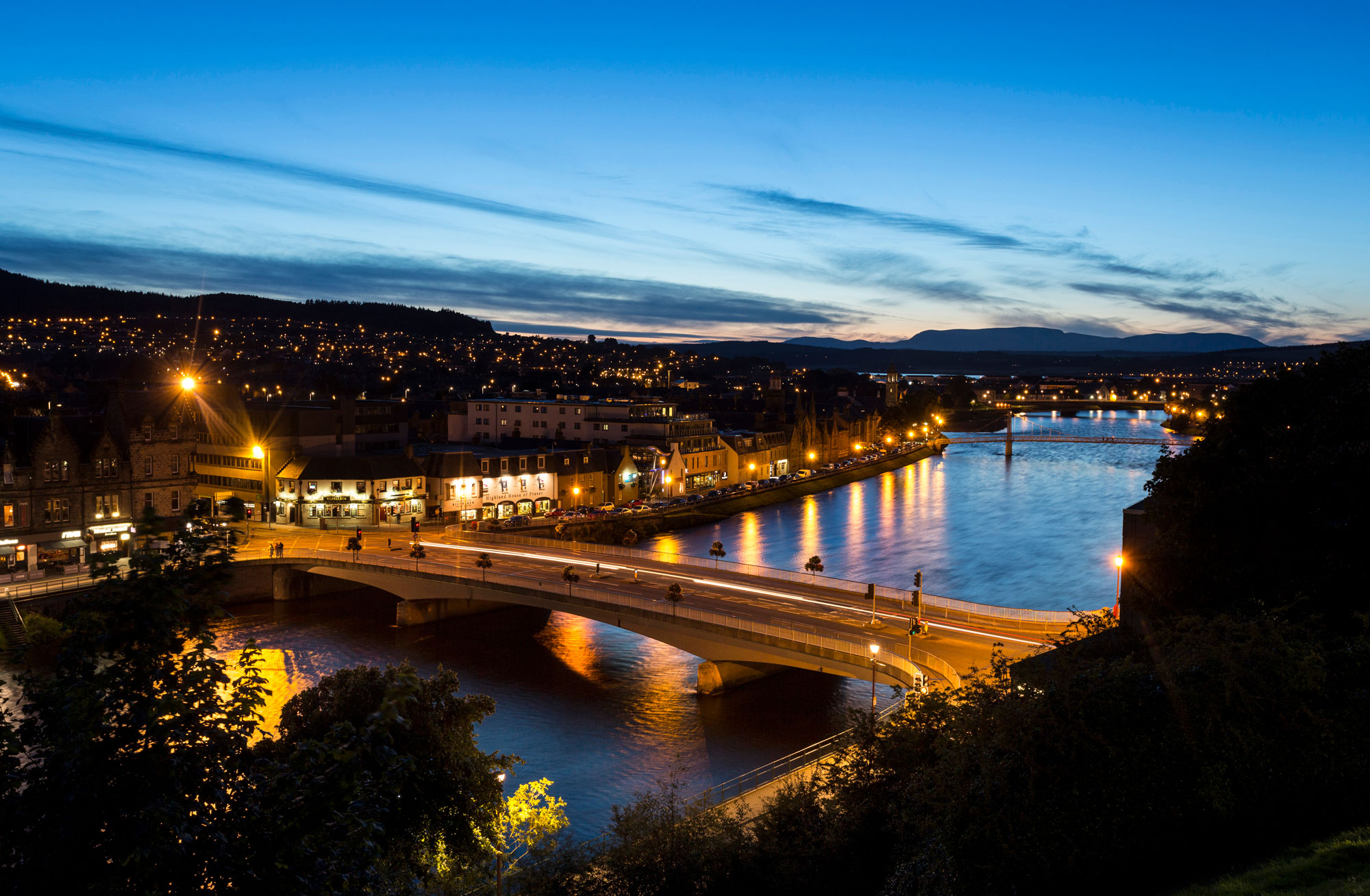 Aerial shot of Inverness lit up at night, looking across the River ness