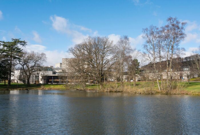 Stirling University buildings just visible across a lake and behind some trees.