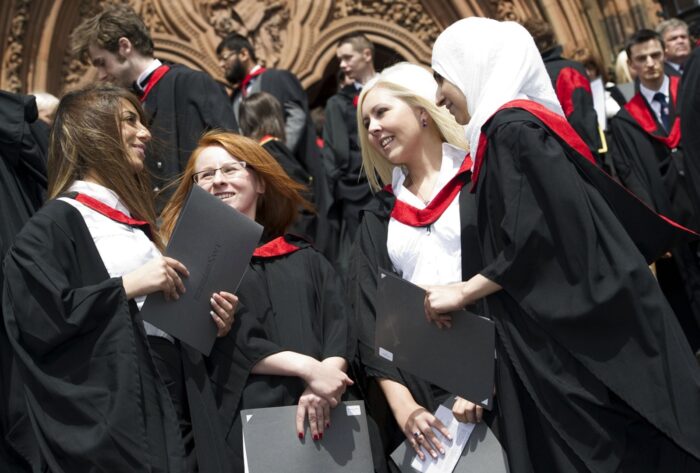 A number of graduates chat outside of the University of the West of Scotland graduation ceremony.